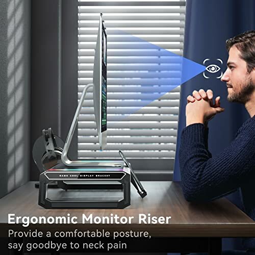 Man using ergonomic monitor riser for comfortable posture at desk.